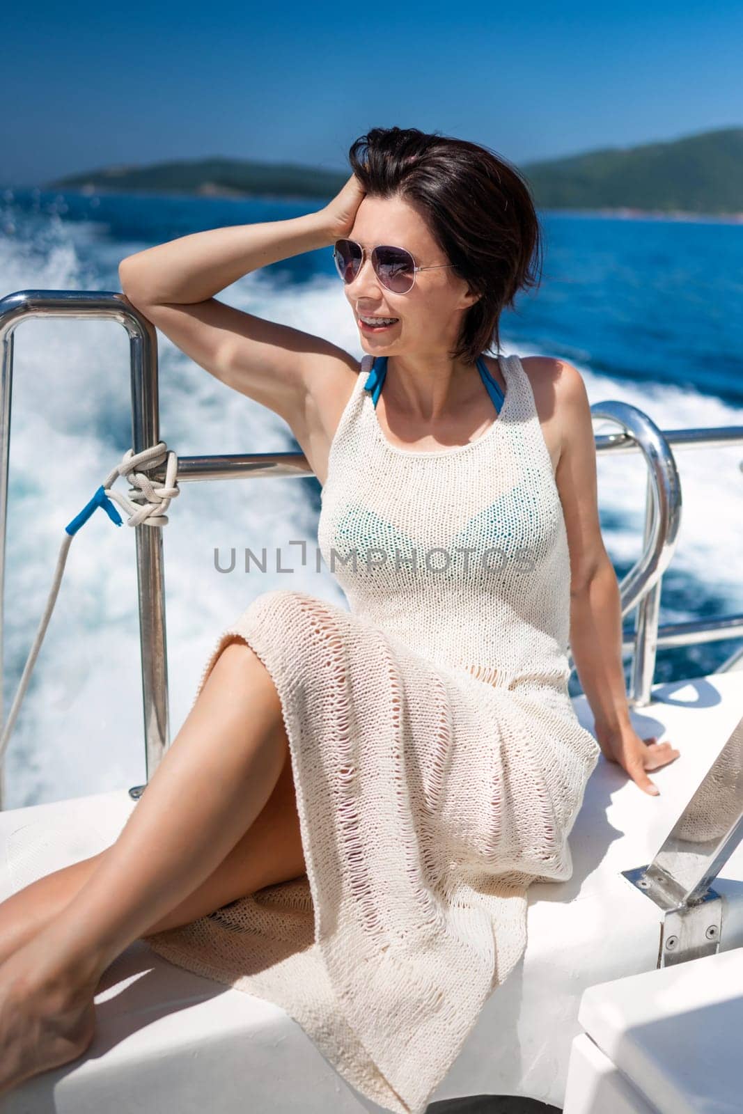Beautiful girl on yacht at summer during sea cruise. Young pretty woman at luxury boat