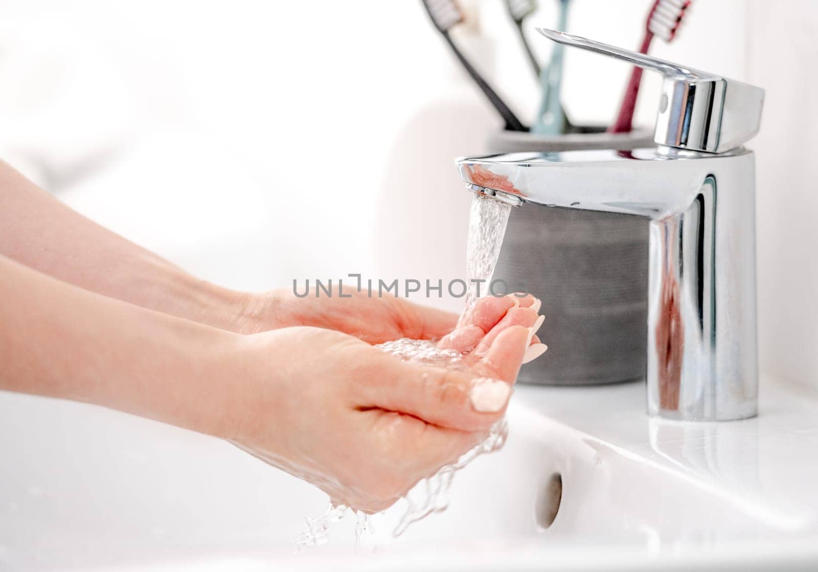 Female Hands Under Faucet Collecting Water In Palms by tan4ikk1