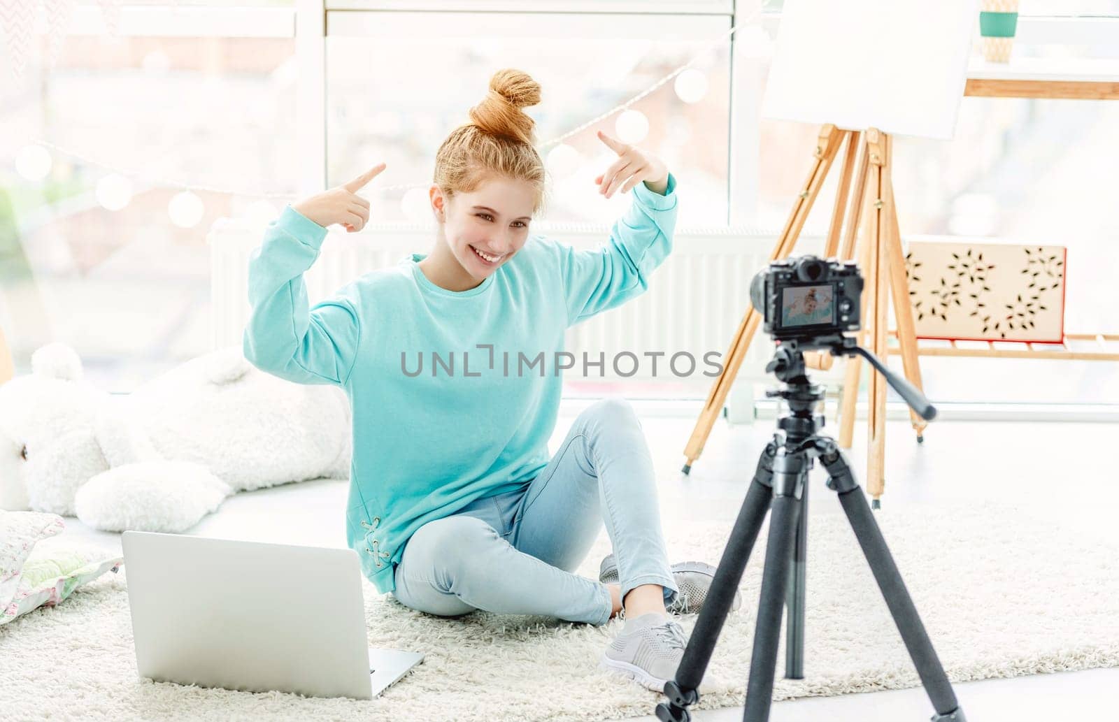 Beautiful girl hugging cute dog in front of camera on tripod