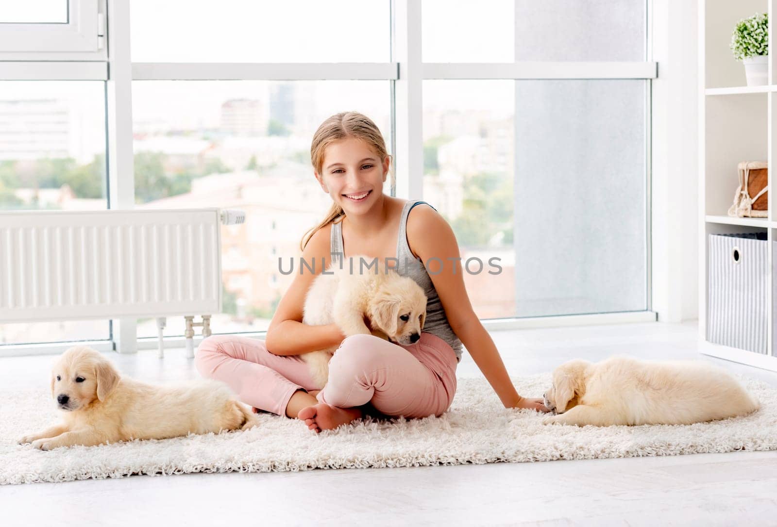 Smiling girl holding retriever puppy