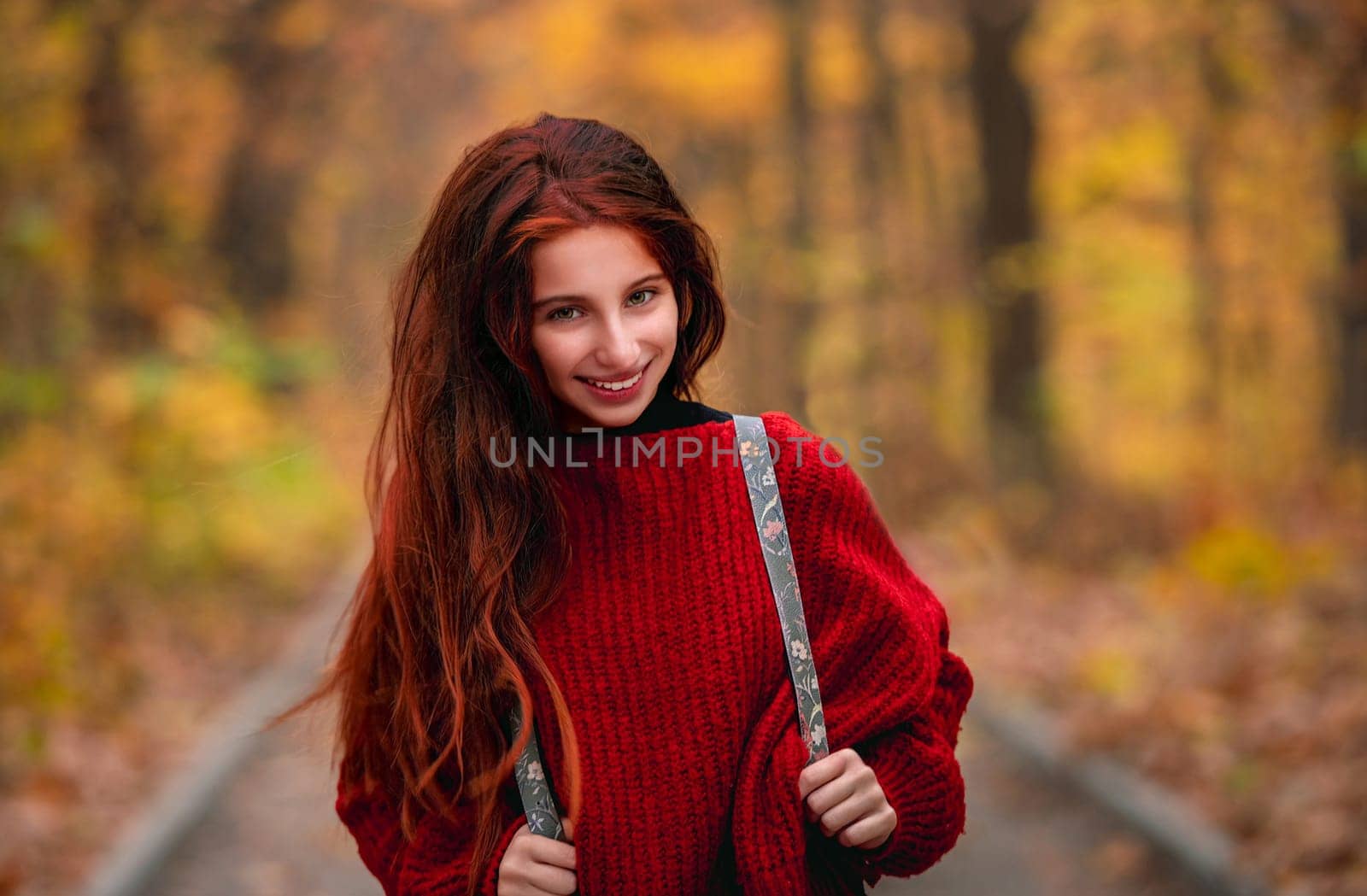 Young girl posing on autumn park road by tan4ikk1