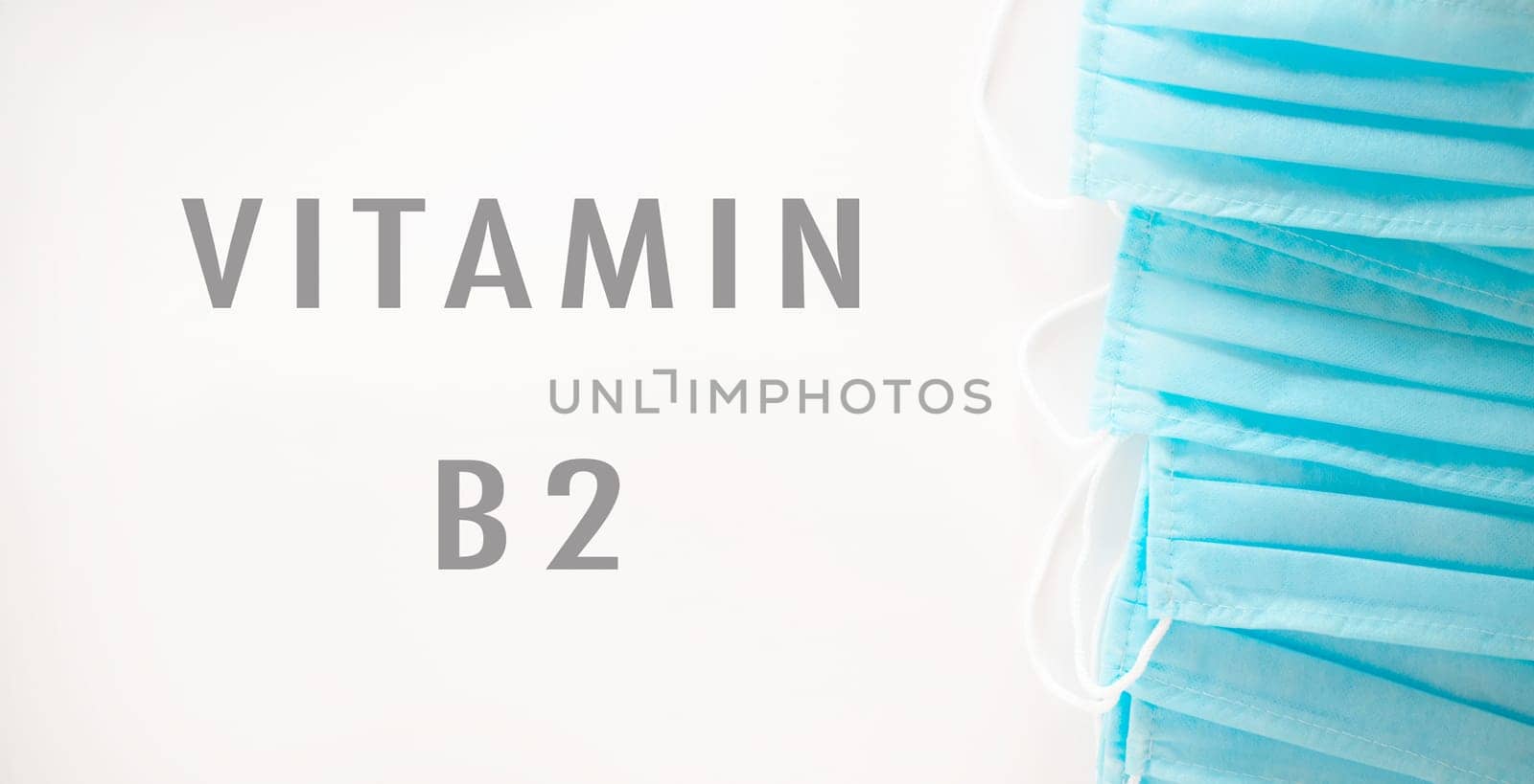 A blue stack of surgical masks with the word vitamin B2 written underneath. Concept of caution and protection, as the masks are used in medical settings to prevent the spread of germs and viruses