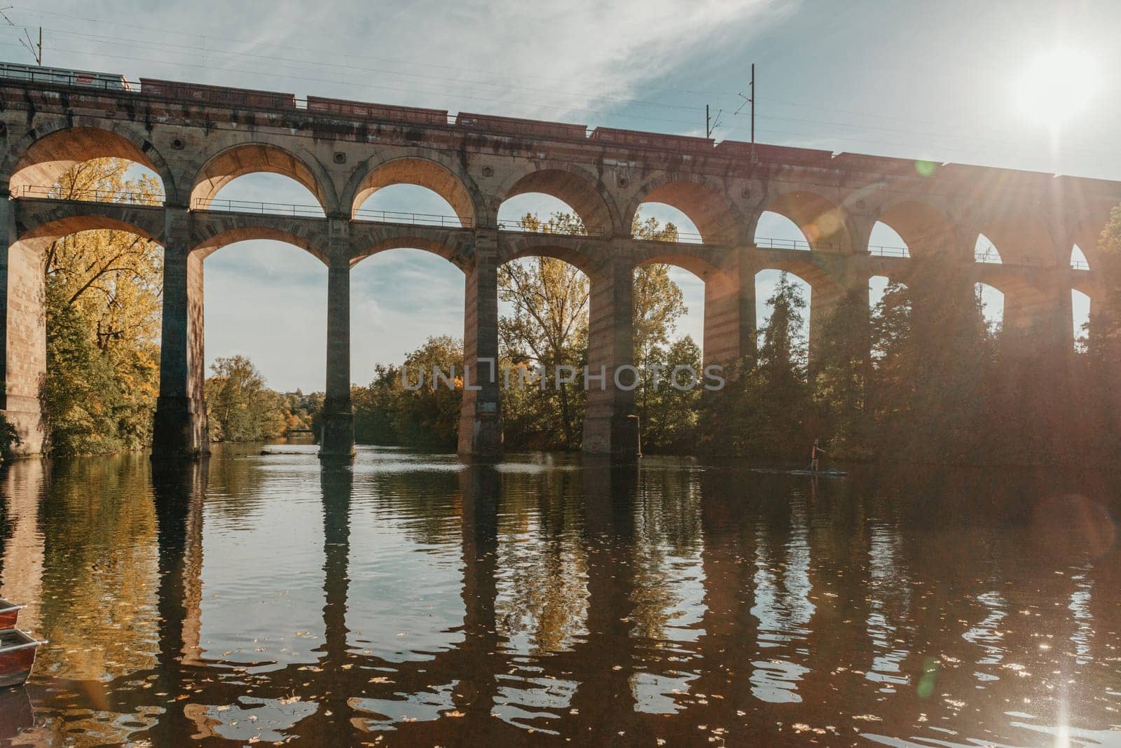 Railway Bridge with river in Bietigheim-Bissingen, Germany. Autumn. Railway viaduct over the Enz River, built in 1853 by Karl von Etzel on a sunny summer day. Bietigheim-Bissingen, Germany. Old viaduct in Bietigheim reflected in the river. Baden-Wurttemberg, Germany. Train passing a train bridge on a cloudy day in Germany