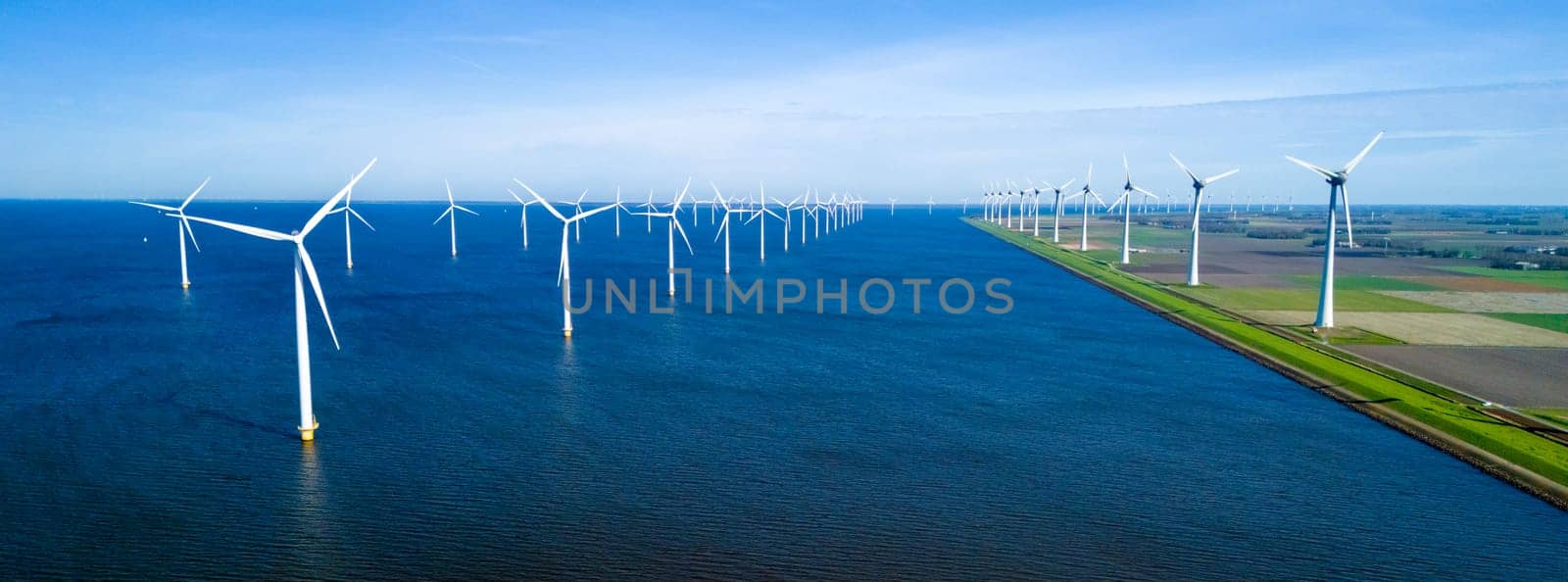 A picturesque scene of numerous windmills scattered across a vast body of water ocean by fokkebok
