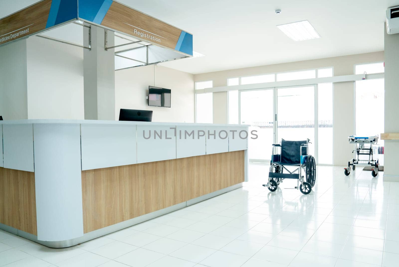 Empty room in area of reception or registration counter in hospital with wheelchair or mobilebed to support healthcare and treatment for patient. by nrradmin
