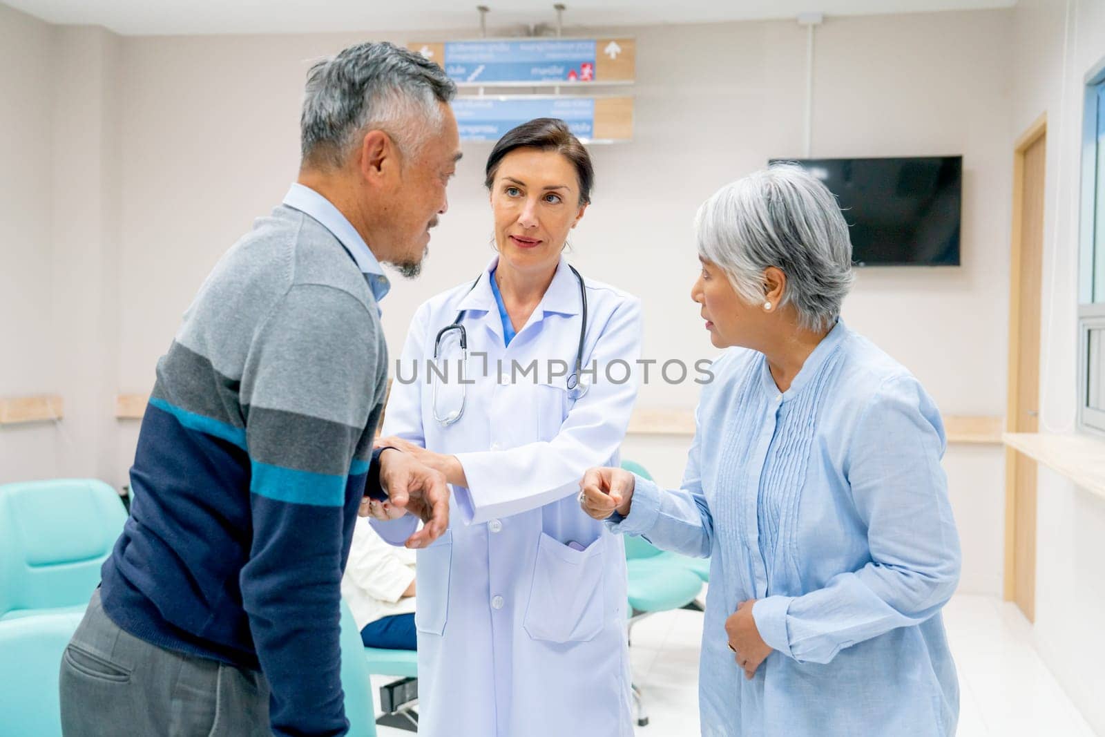 Close up of Caucasian doctor woman help to consult and give suggestion to senior man and woman in front of pharmacy counter in hospital.