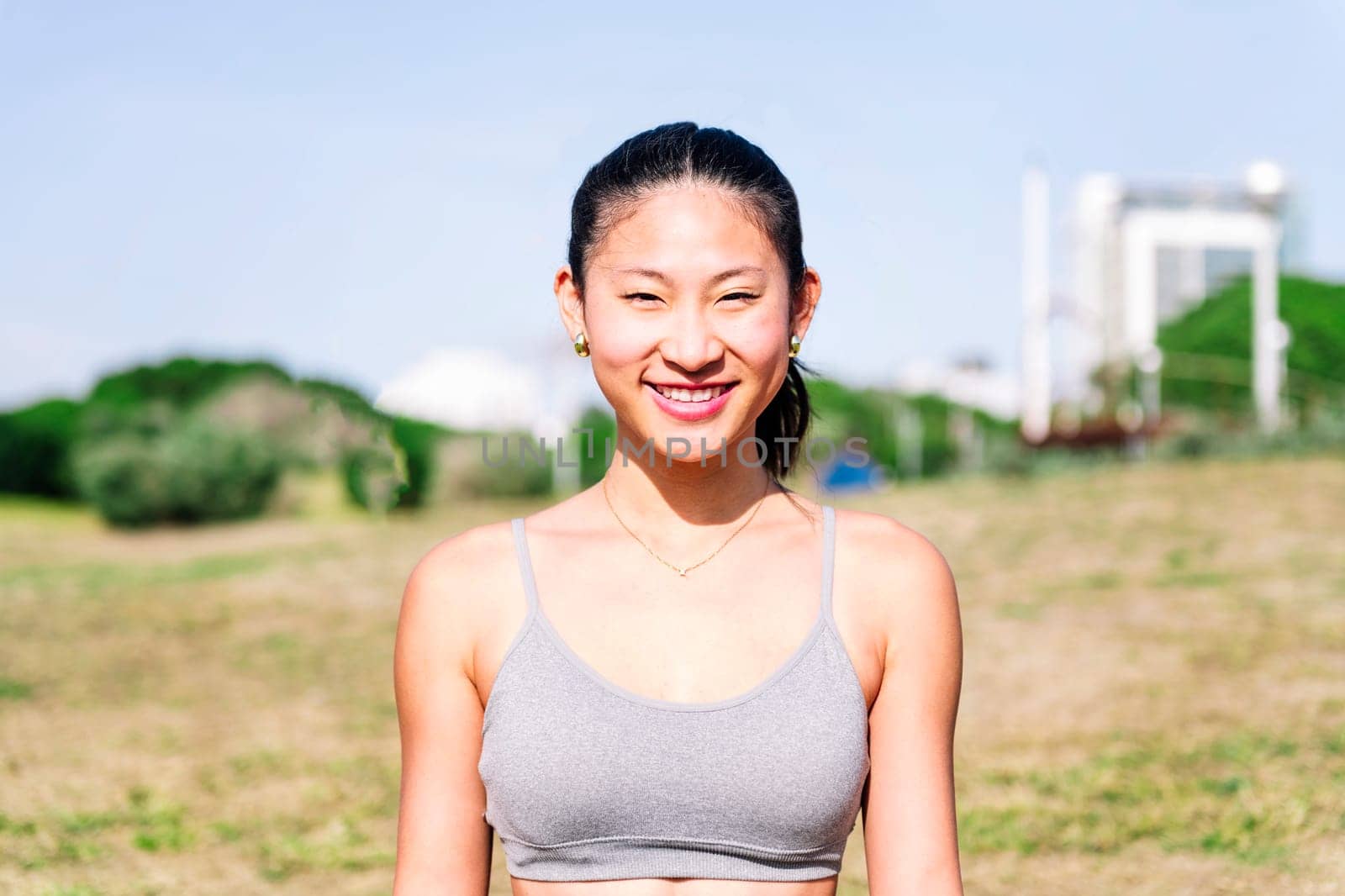 Portrait of a young asian woman in sportswear smiling happy looking at camera