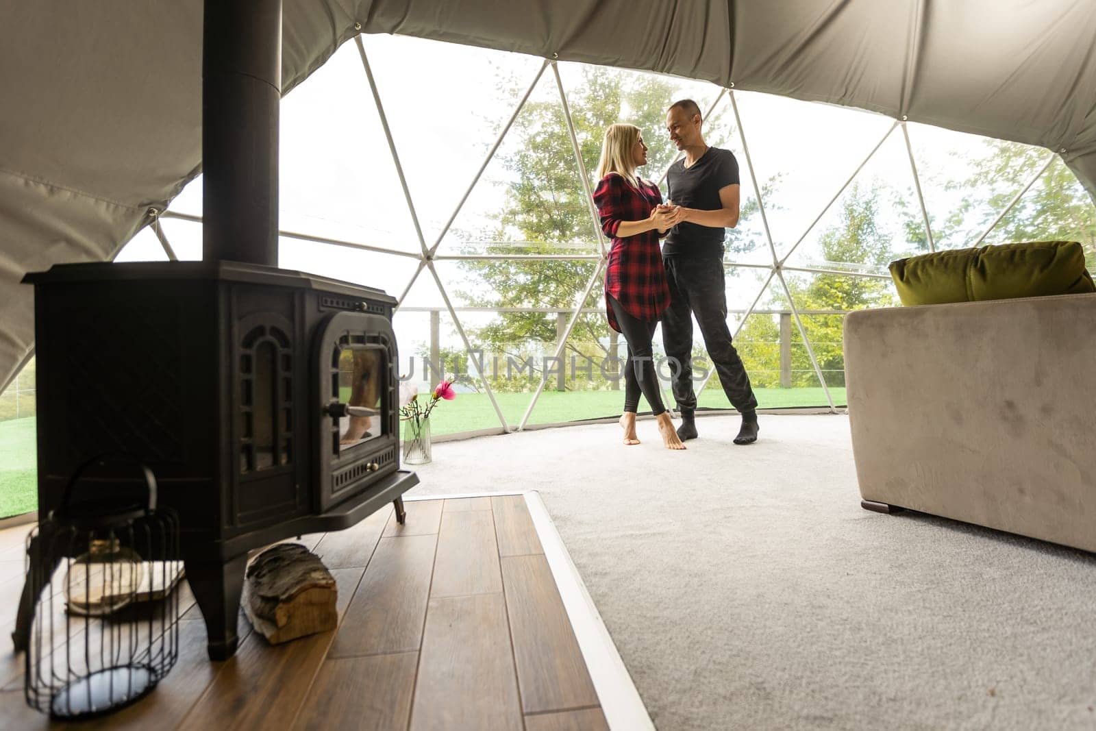 a couple in geo dome tents. Cozy, camping, glamping, holiday, vacation lifestyle concept. Outdoors cabin, scenic background