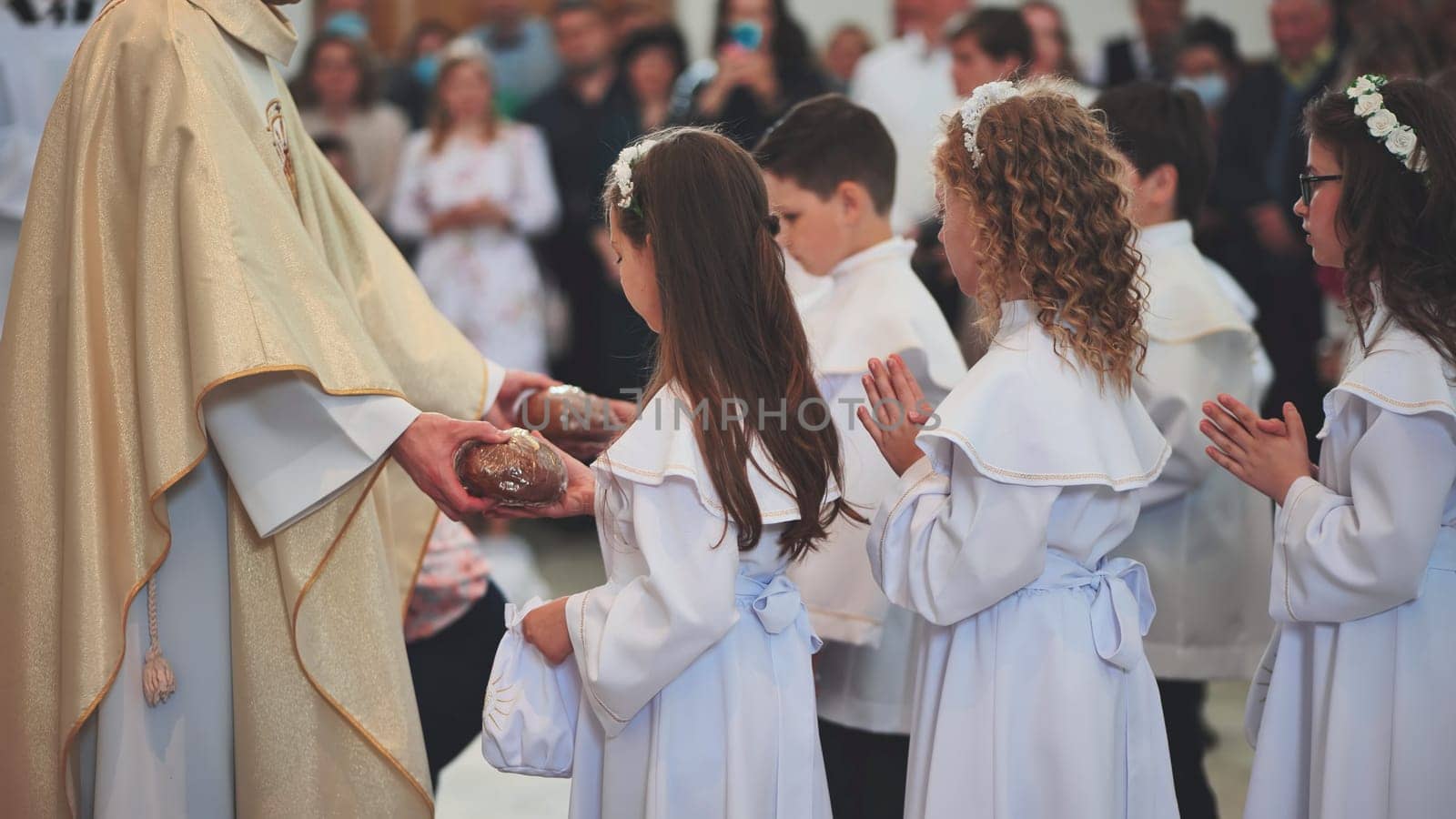 Children receive bread from the priest in the Catholic Church