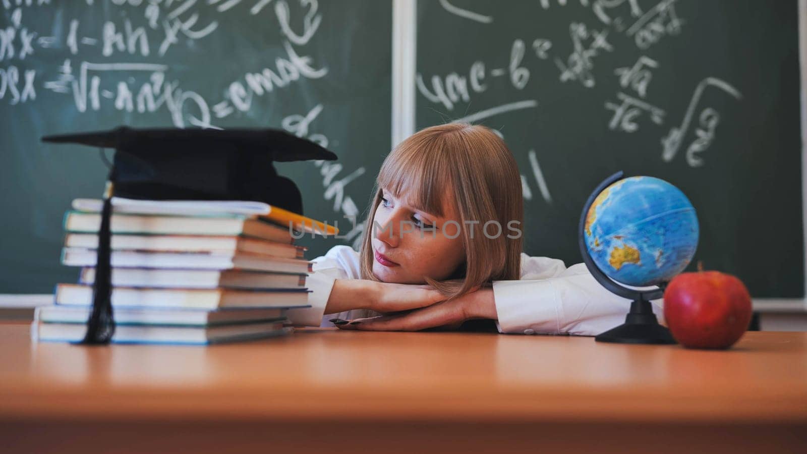 Blonde schoolgirl with bangs poses in front of school objects.