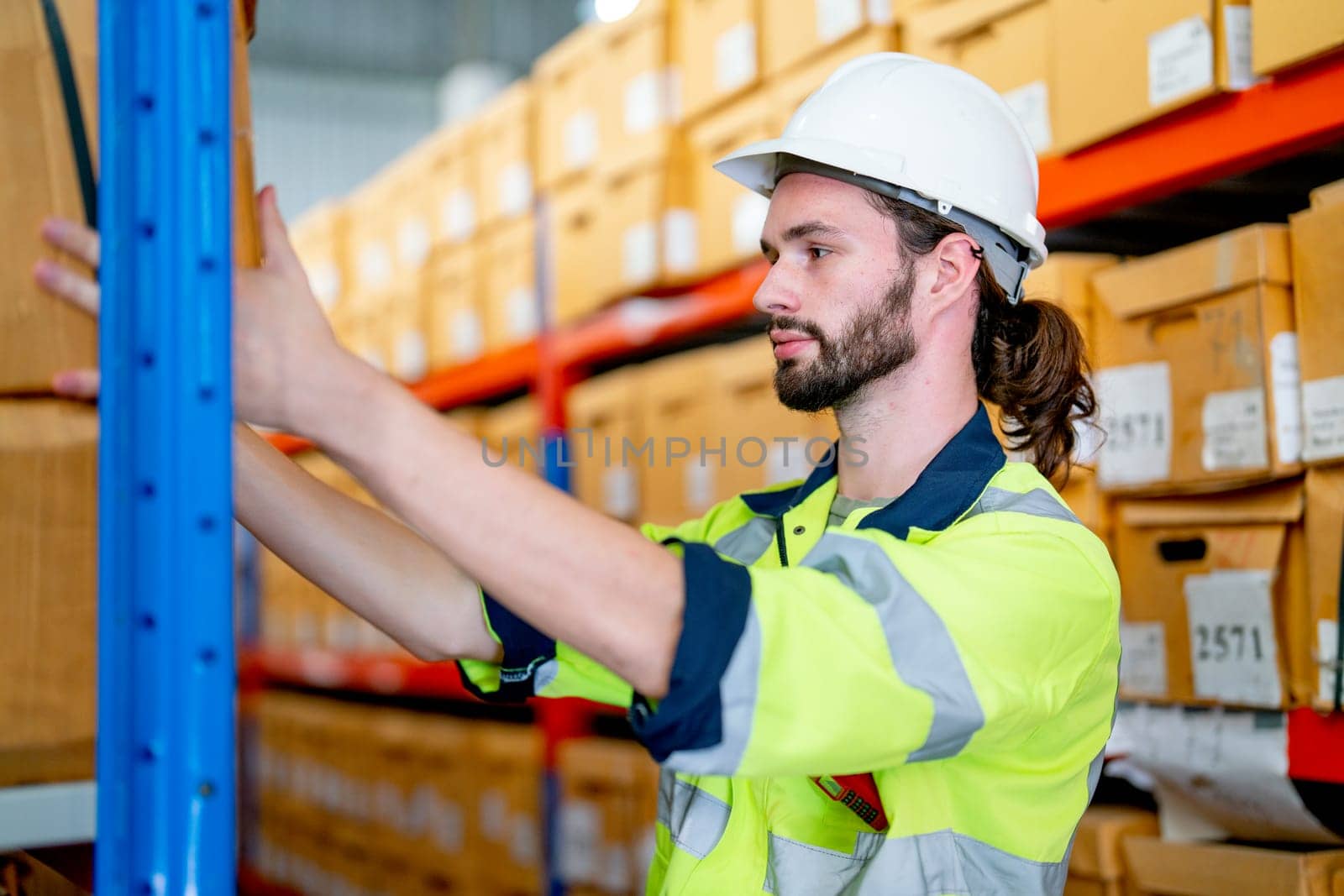 Close up smart warehouse worker man hold box on shelves to carry or send to the customer in workplace area. by nrradmin