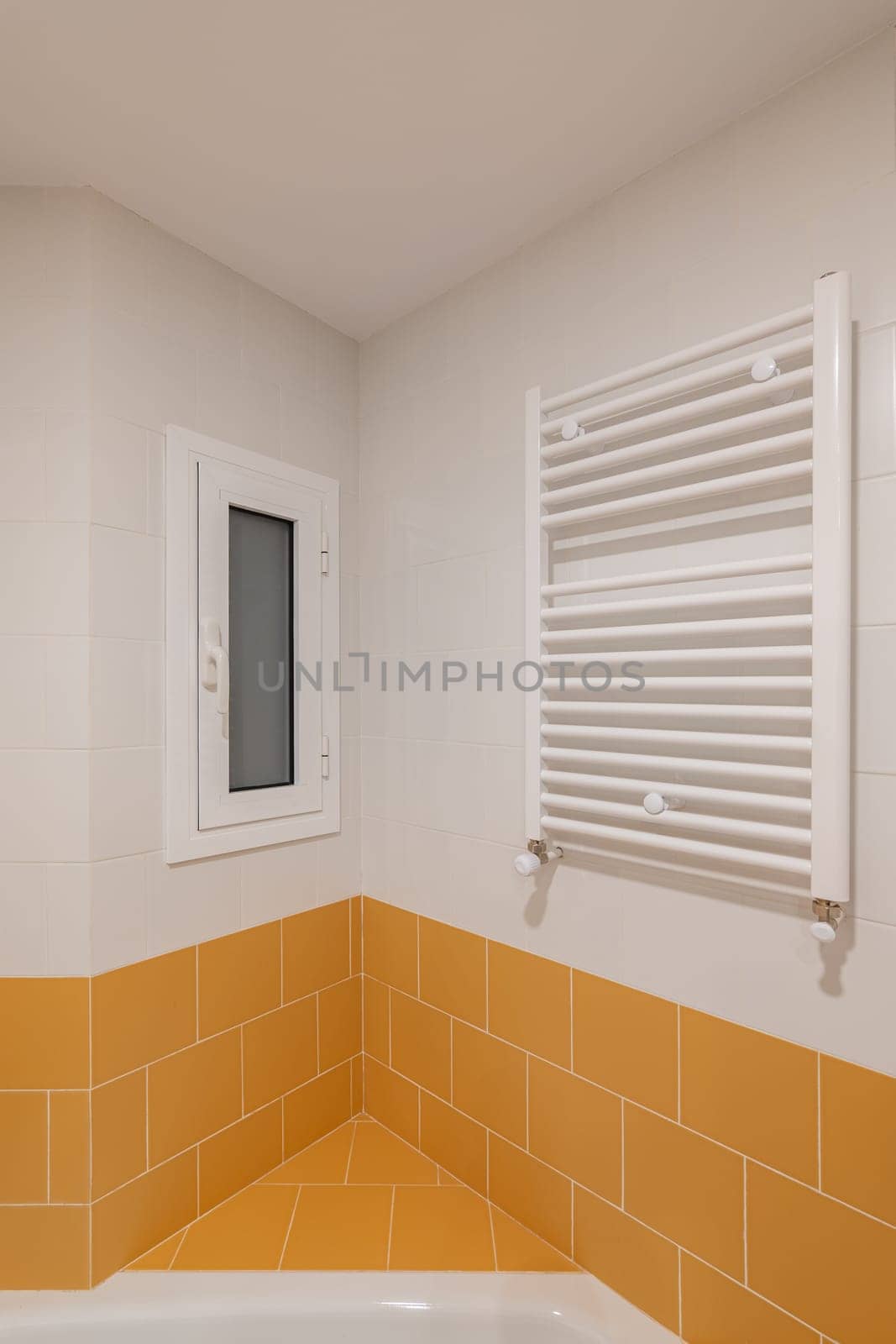 A Bathroom With Yellow Tiles And A White Towel Rack by apavlin