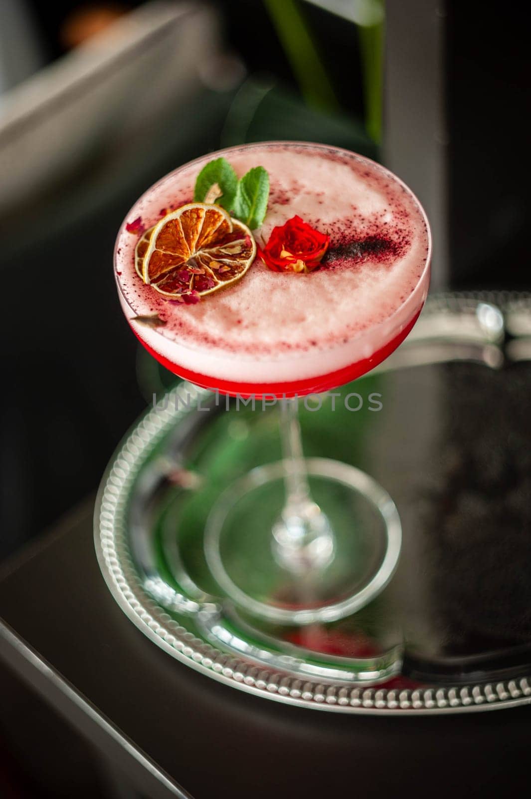Pink lady alcoholic cocktail drink with gin, grenadine syrup, lemon juice and egg white, dark background. High quality photo
