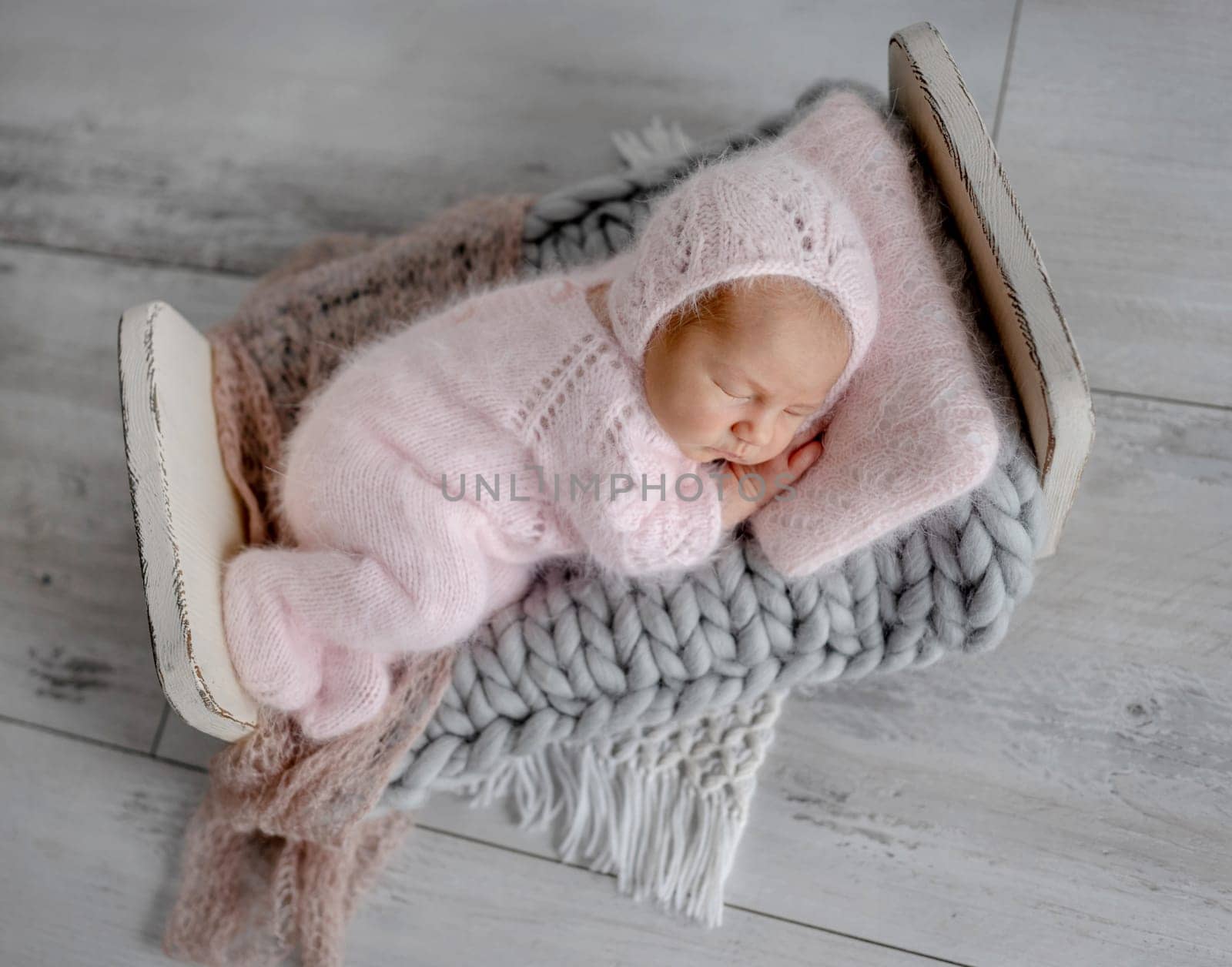 Newborn Girl In Lace Dress Lies On Chair In pink Tones Photo