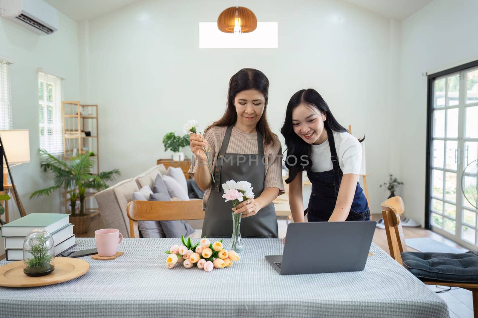 Mother and daughter arrange flower together at home on the weekend, family activities, mother and daughter do activities together on Mother's Day.