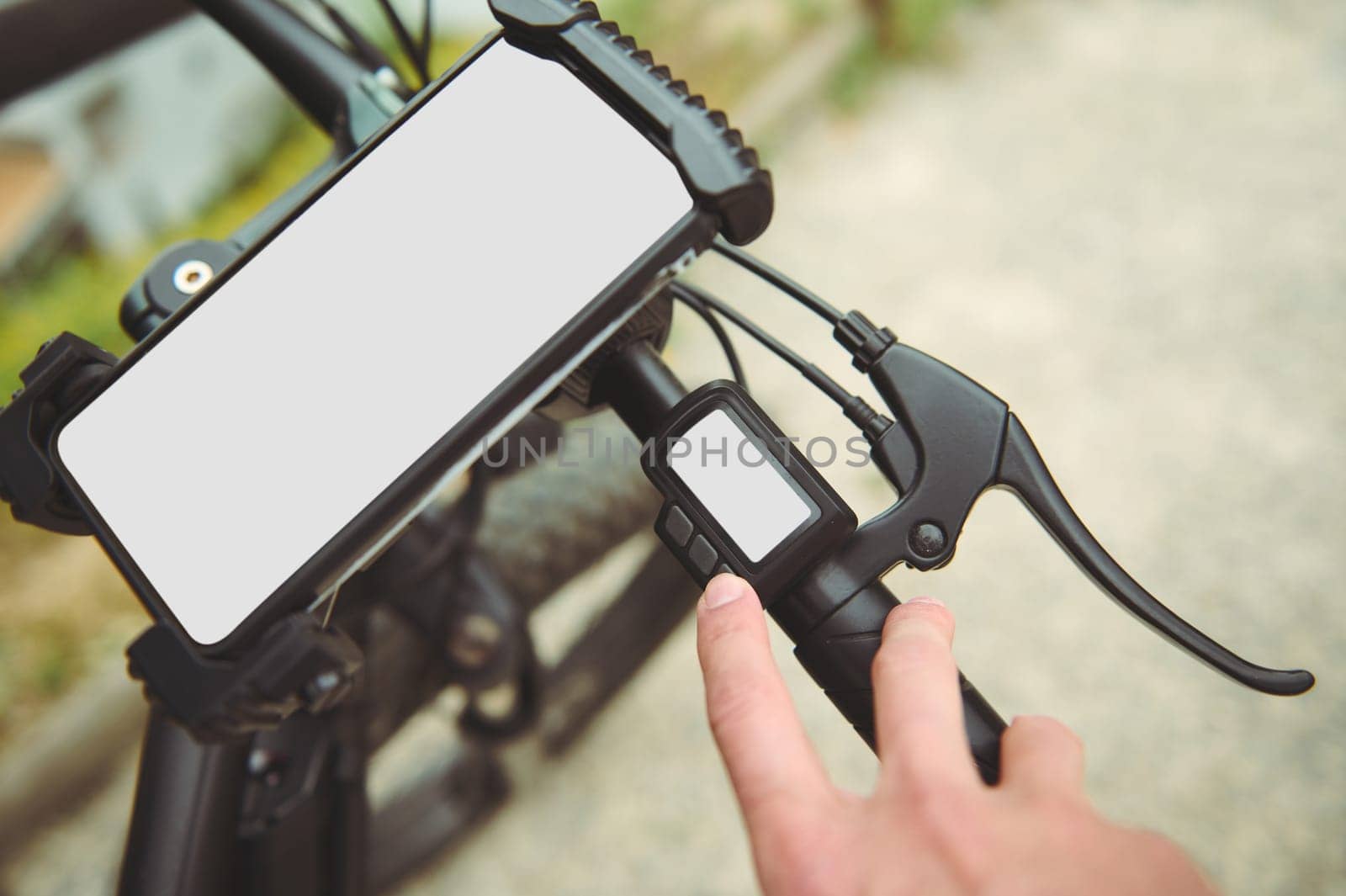 Close-up man planning route using GPS navigation application in mobile phone on his electric bicycle bike. White blank mockup digital screen on smartphone, copy advertising space for mobile app by artgf