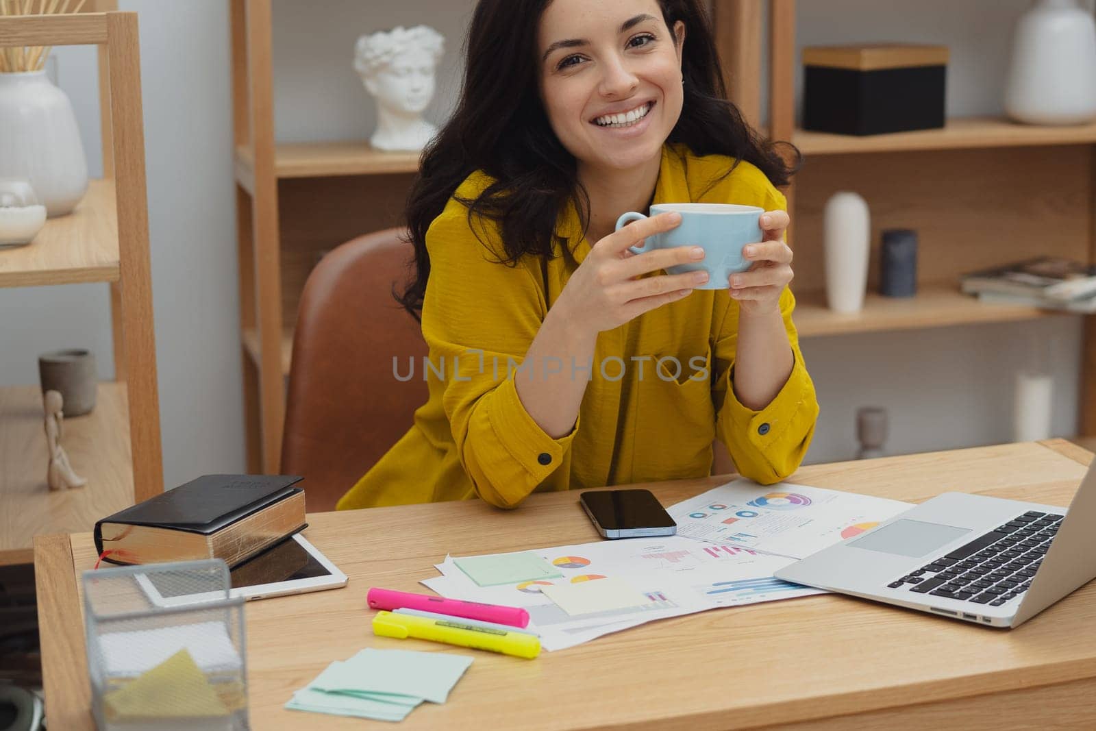 Thoughtful young woman in eyewear using computer while sitting on the sofa at home. High quality photo