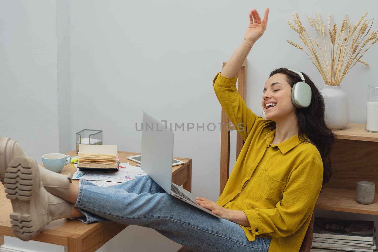 Thoughtful young woman in eyewear using computer while sitting on the sofa at home. High quality photo