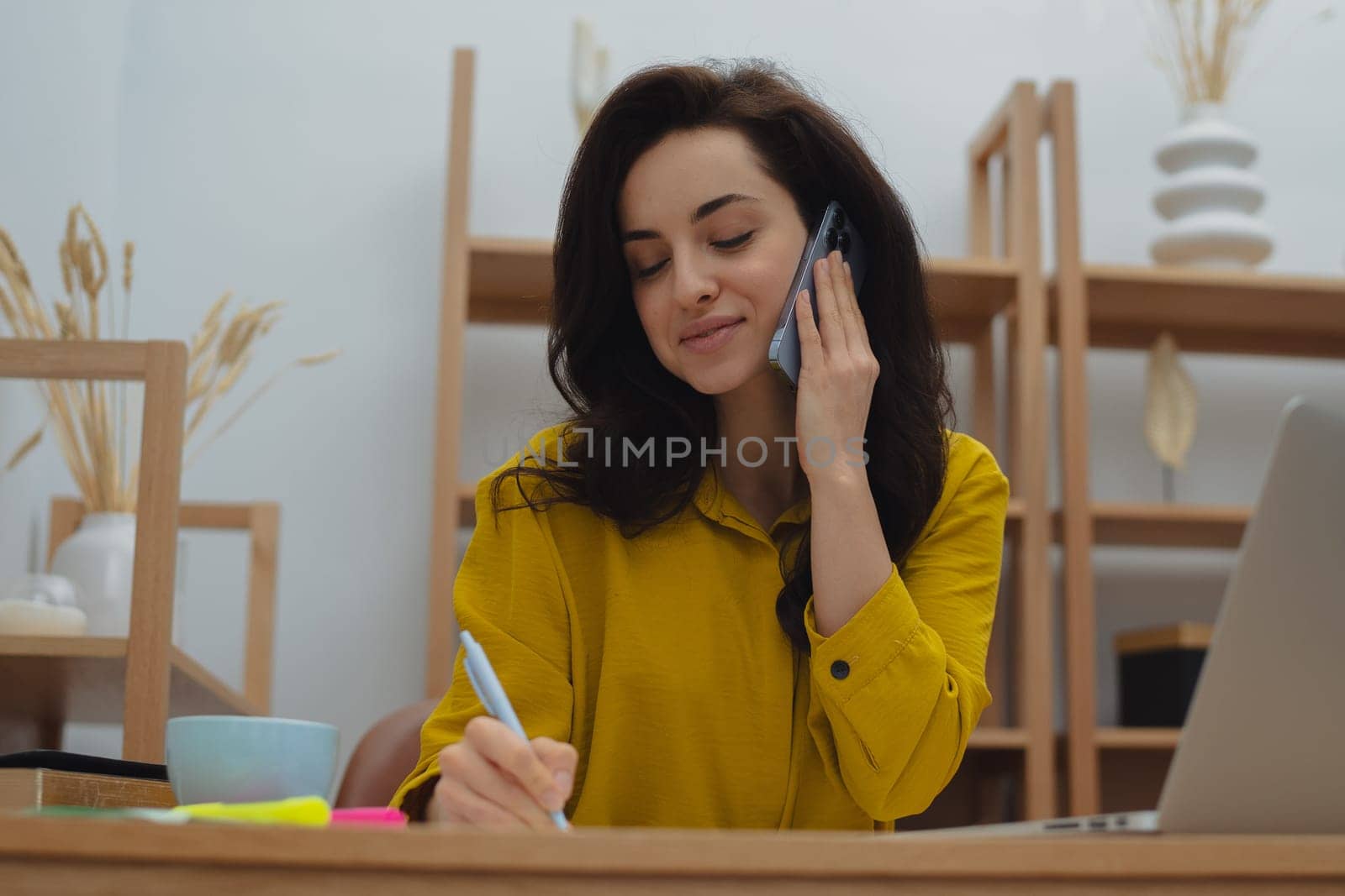 Thoughtful young woman in eyewear using computer while sitting on the sofa at home. High quality photo