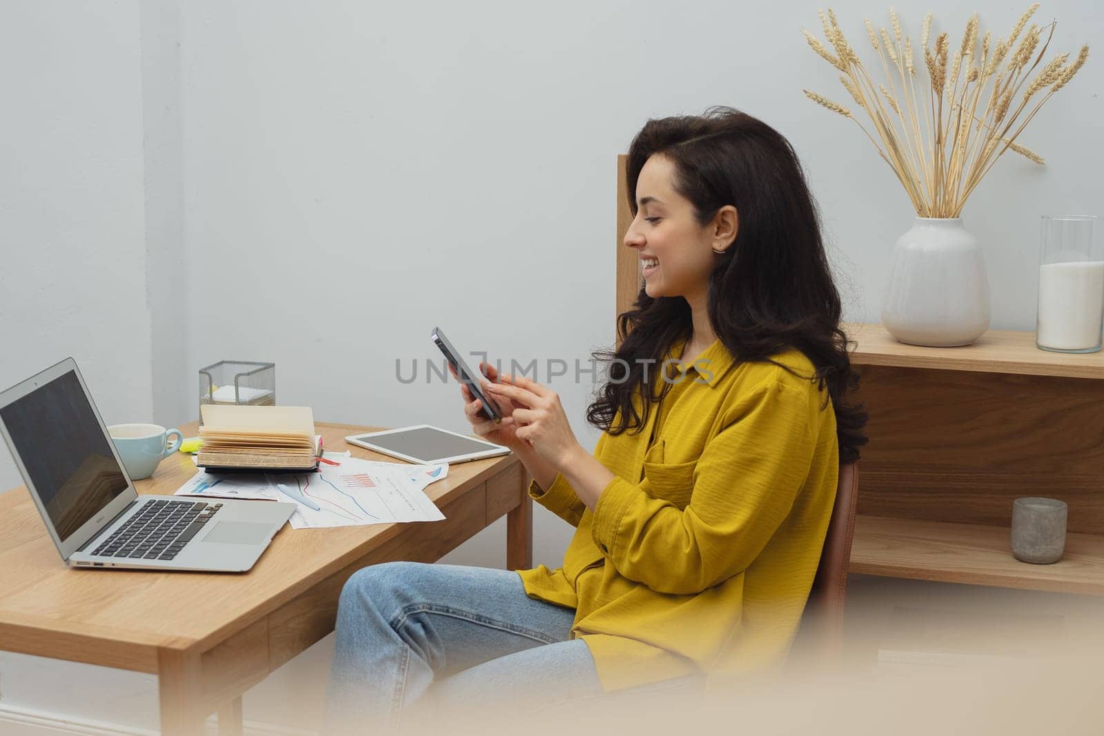 Thoughtful young woman in eyewear using computer while sitting on the sofa at home. High quality photo