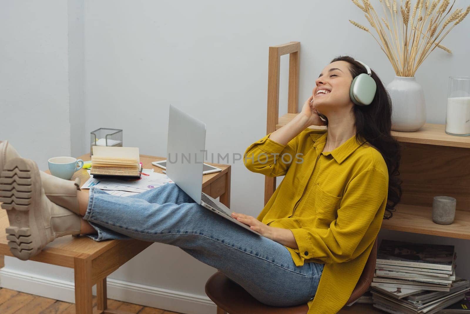 Thoughtful young woman in eyewear using computer while sitting on the sofa at home. High quality photo