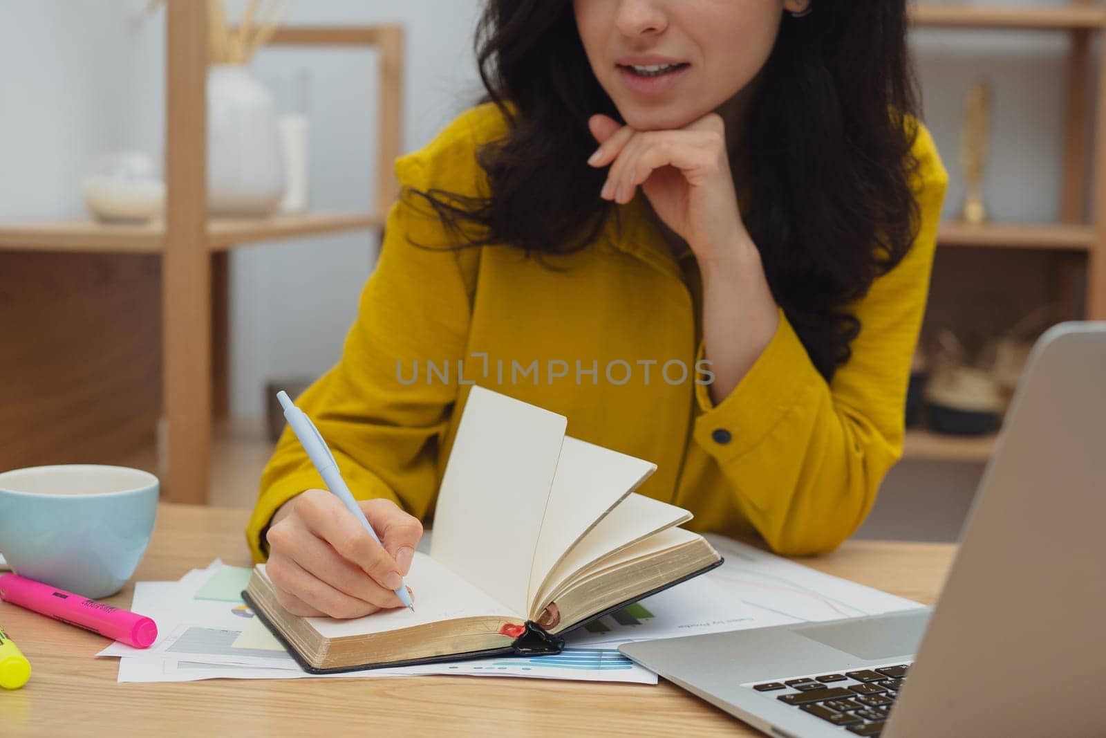Thoughtful young woman in eyewear using computer while sitting on the sofa at home. High quality photo