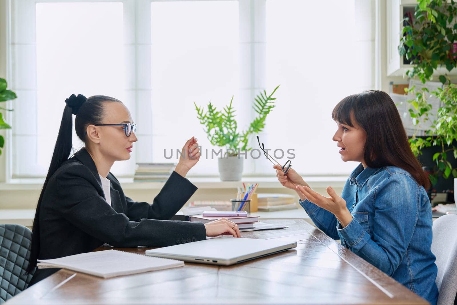 Mental therapy session of sad unhappy depressed stressed mature female with professional psychologist counselor. Talking serious women sitting at table, psychology psychotherapy support help treatment