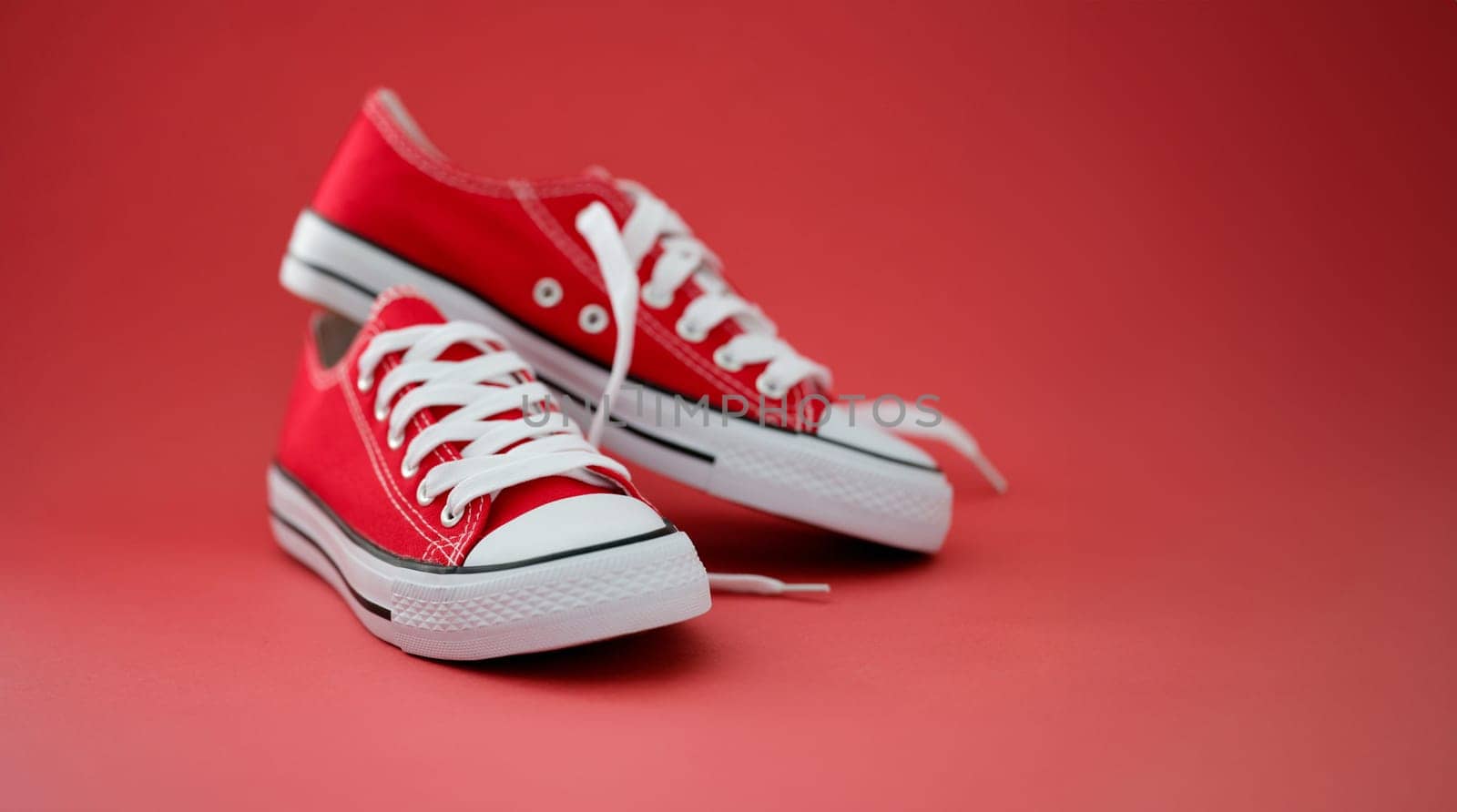 Fashionable red sports sneakers with white laces. Sports shoes concept