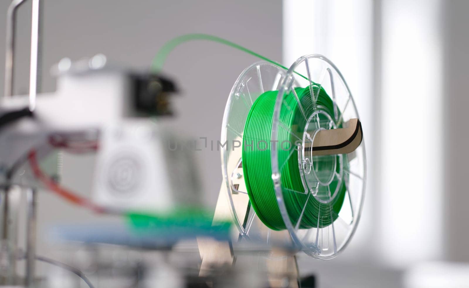 Green plastic string 3D printer consumable closeup. Modern computer technology concept