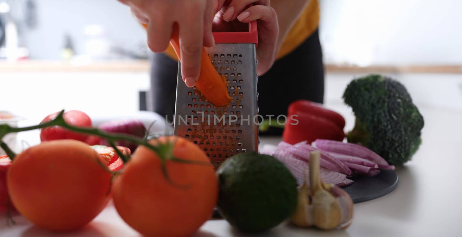 Chef grating carrots to make vegetable salad closeup by kuprevich