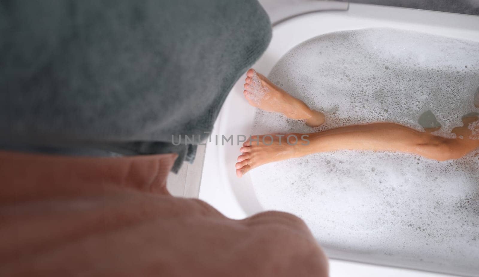 Female feet lying in water in bath closeup top view by kuprevich