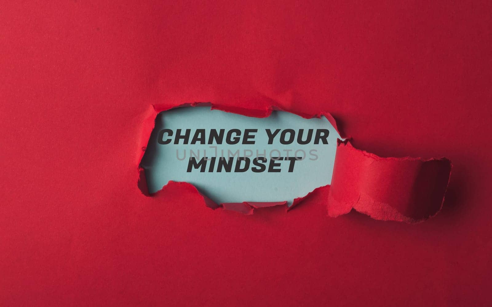 A red background with a torn piece of paper with the words Change Your Mindset by Alla_Morozova93