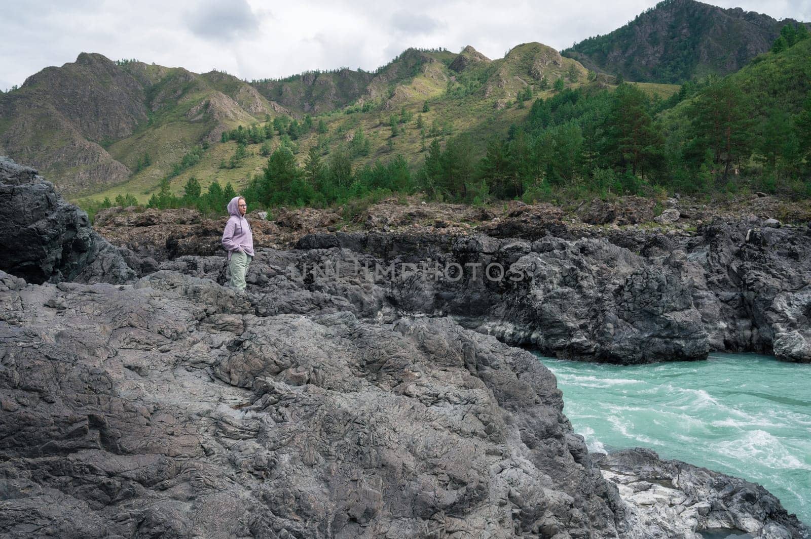 Woman at the river Katun at summer day. Trip on Altai Mountains in Altai Republic