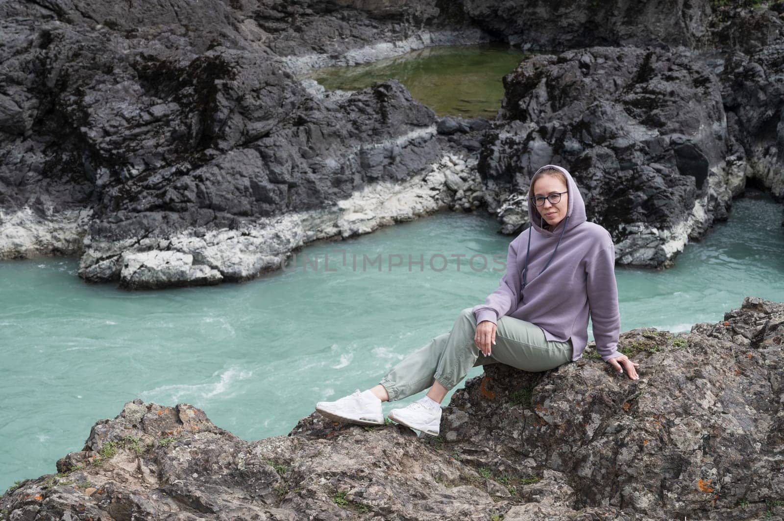 Woman at the river Katun at summer day. Trip on Altai Mountains in Altai Republic