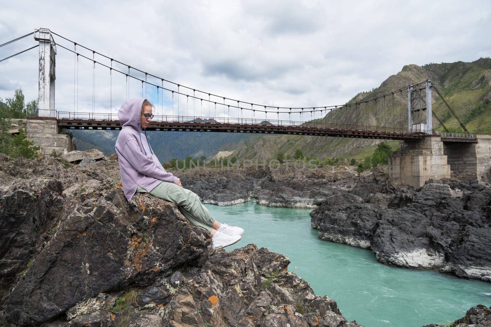 Woman at the river Katun at summer day. Trip on Altai Mountains in Altai Republic