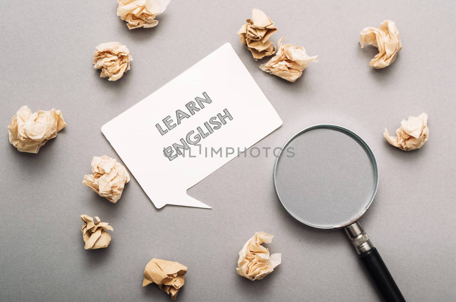 A white sign with the word learn written on it is surrounded by shredded paper. The shredded paper is scattered around the sign, creating a sense of chaos and disarray