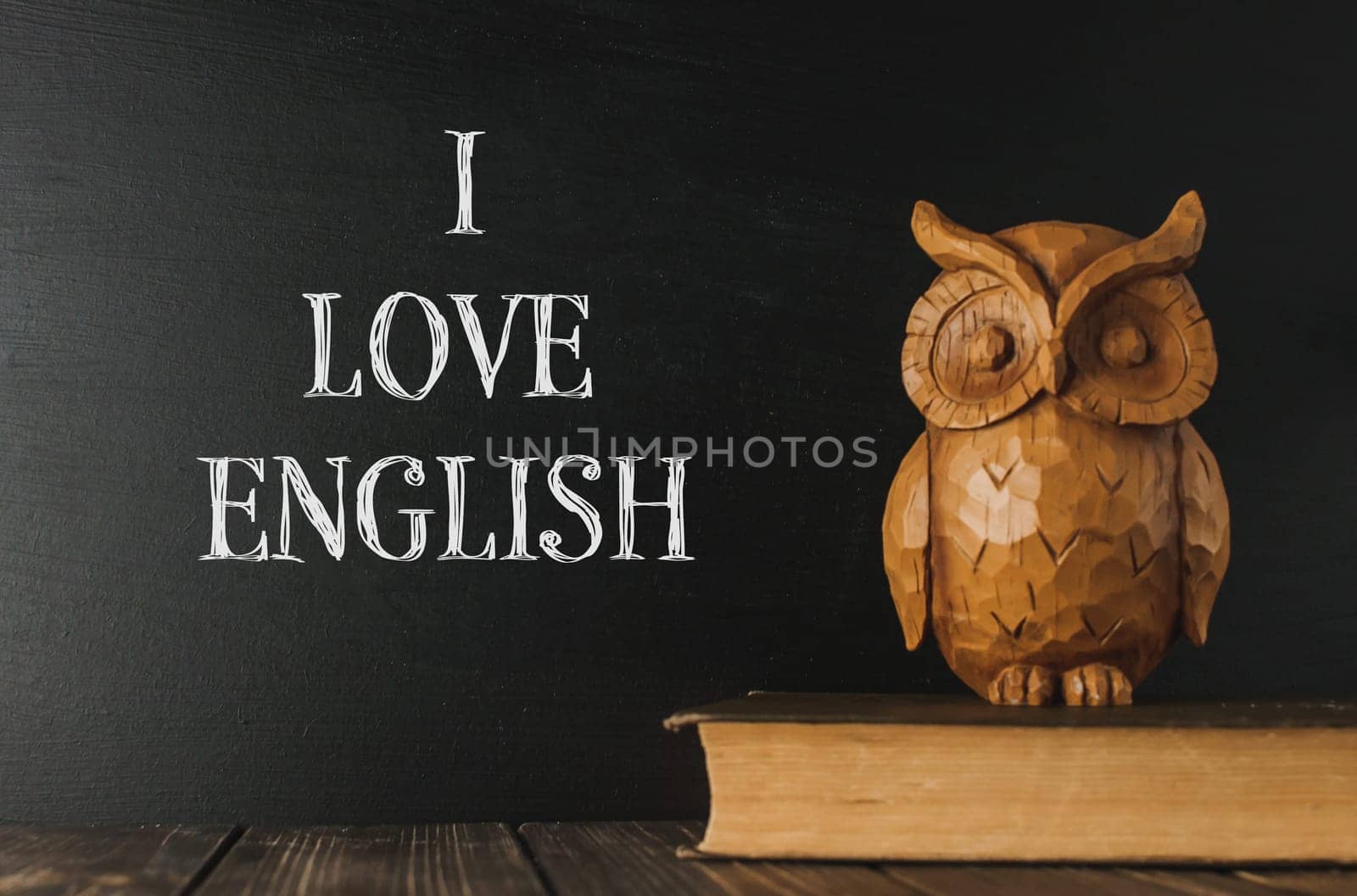 A wooden owl sits on a book with the words I love English by Alla_Morozova93