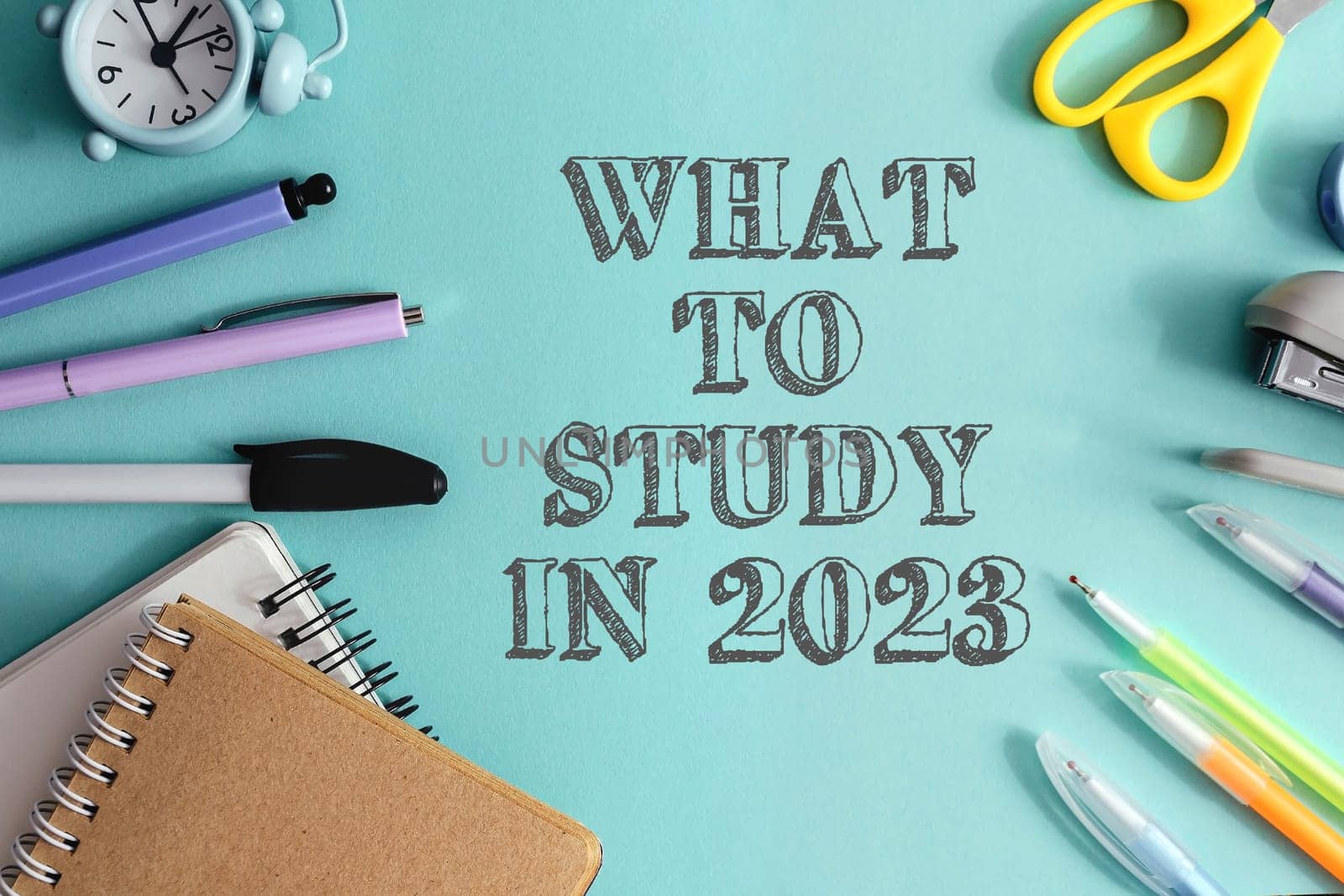 A blue background with a clock, scissors, pens, and pencils. The text What to Study in 2023 is written in white
