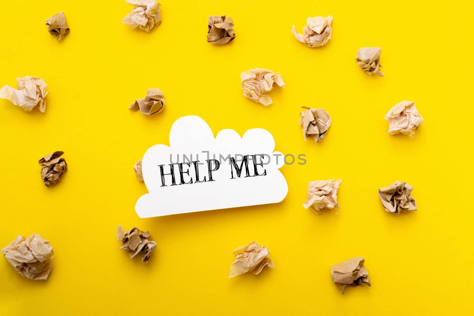 A yellow background with a white sign that says Help Me on it. The sign is surrounded by shredded paper