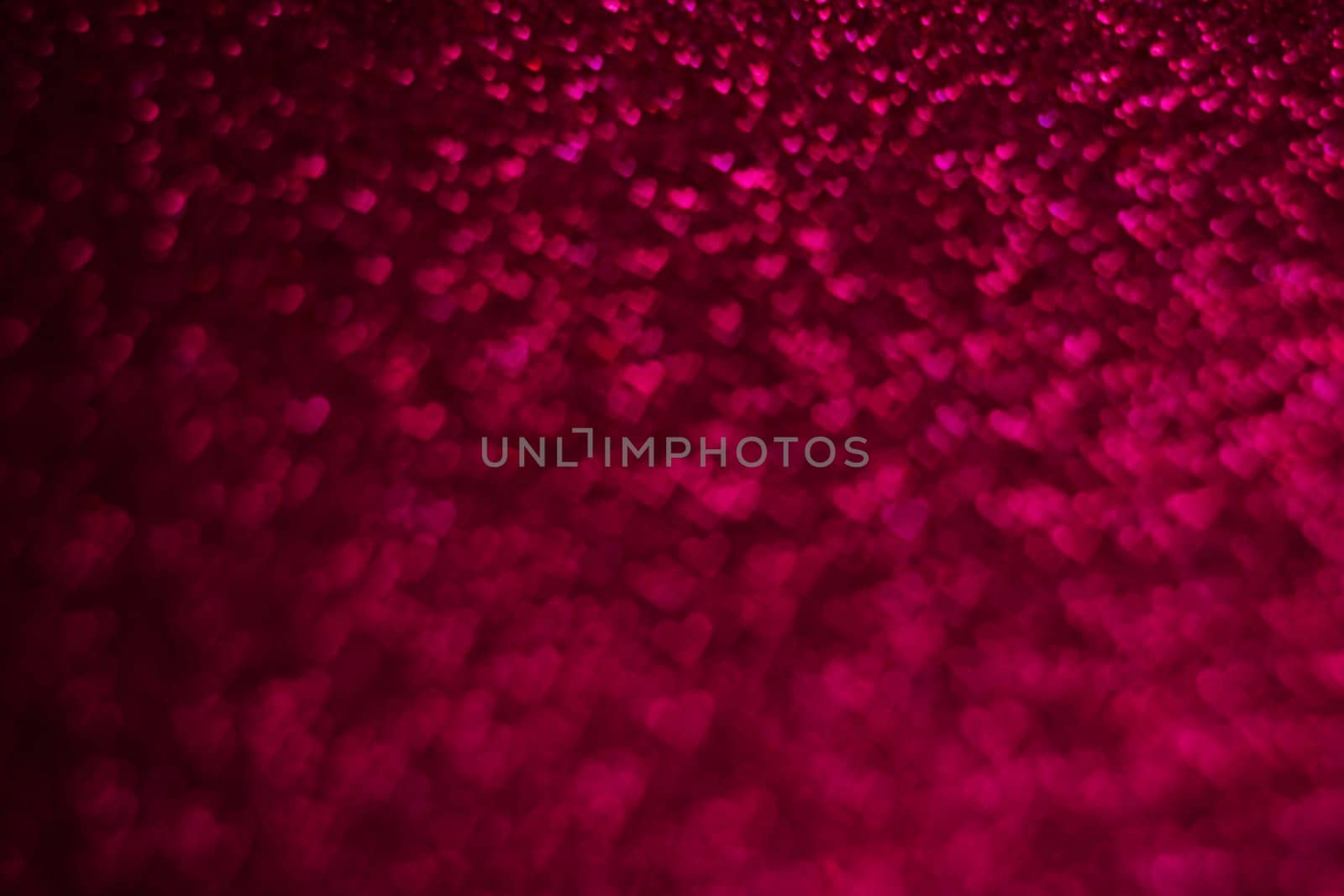 A close up of a red background with many small heart shapes scattered throughout. Concept of love and warmth, as the hearts are arranged in a way that creates a cozy and intimate atmosphere