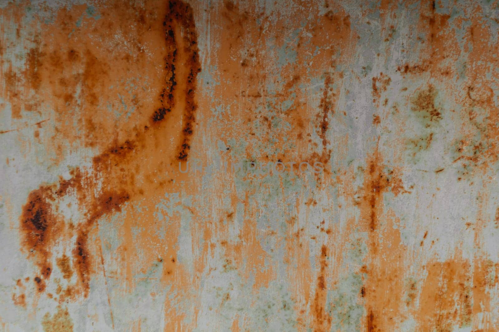 The image is of a rusty metal surface with a greenish tint. The surface is covered in rust and has a worn, aged appearance. The combination of the rust and greenish tint creates a sense of decay
