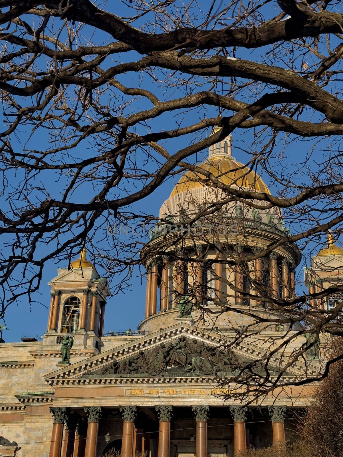 front of St. Isaac's Cathedral through branches of trees in St. Petersburg - Russia in the spring sun. High quality photo