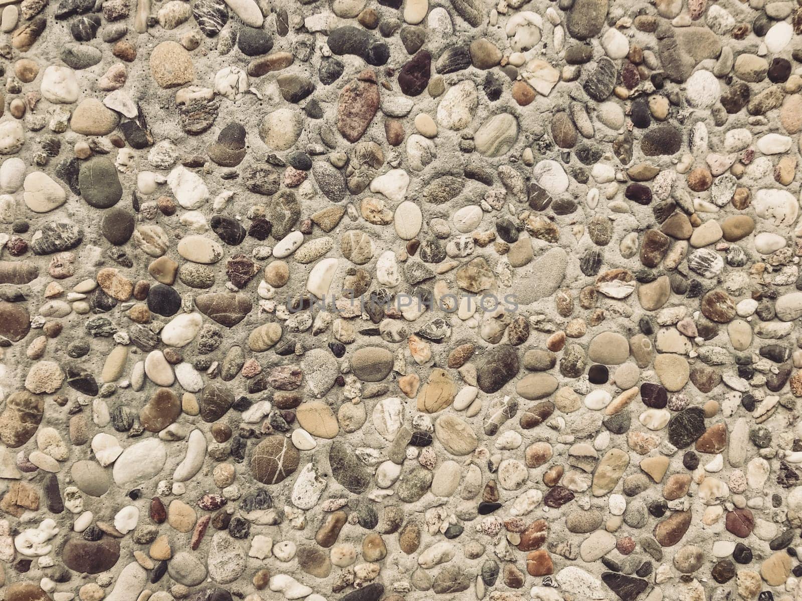 A rocky surface with a variety of sizes and shapes of rocks. The rocks are scattered all over the surface, creating a rough and uneven texture. Concept of ruggedness and natural beauty