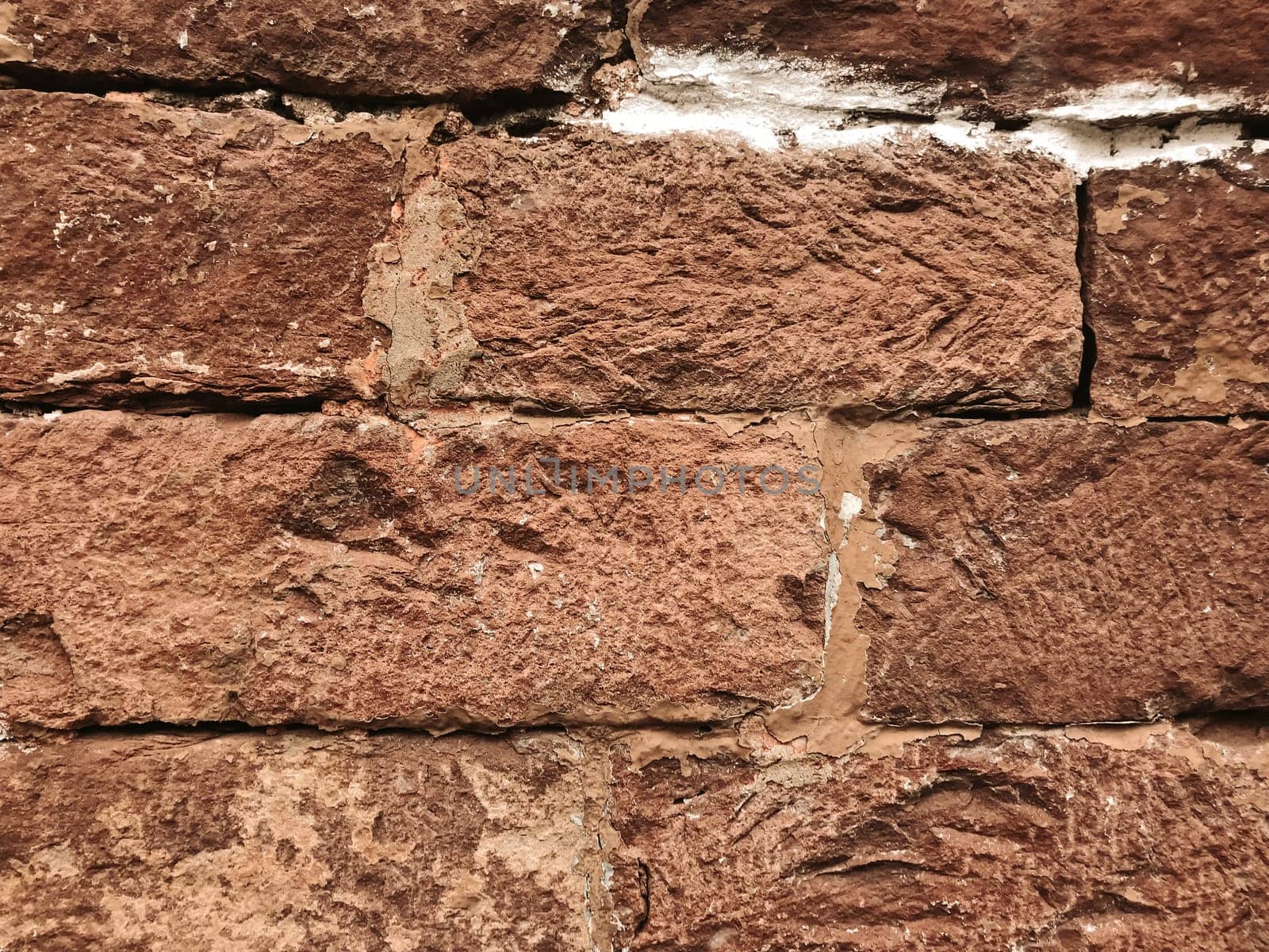 A brick wall with a white line on it. The wall is old and has a rough texture