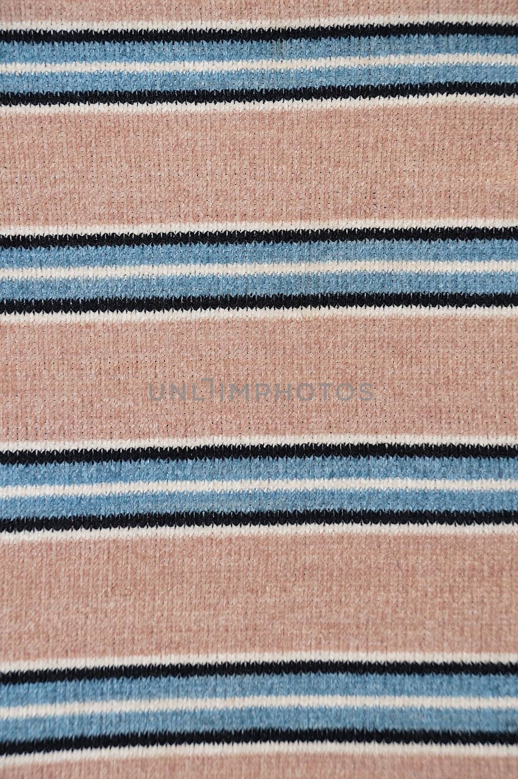 Knitted material closeup with striped pattern in beige, blue and black colors for textile striped background