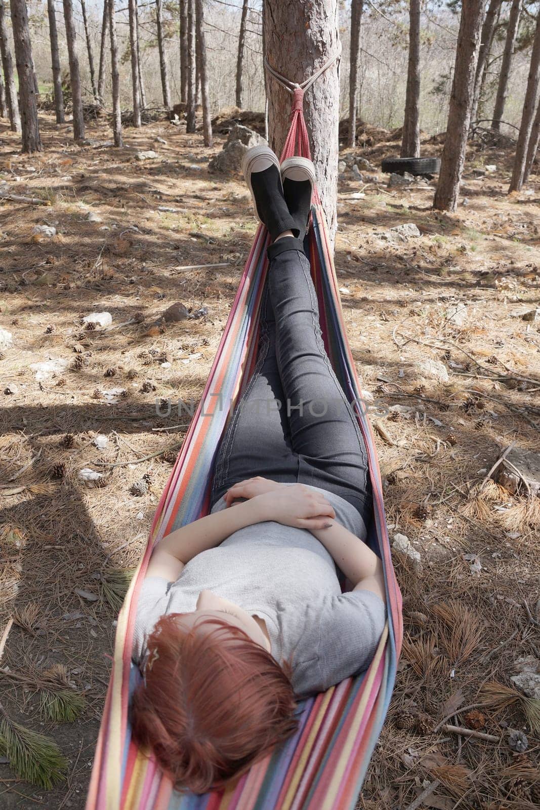 girl resting in a colorful hammock in the woods by Annado