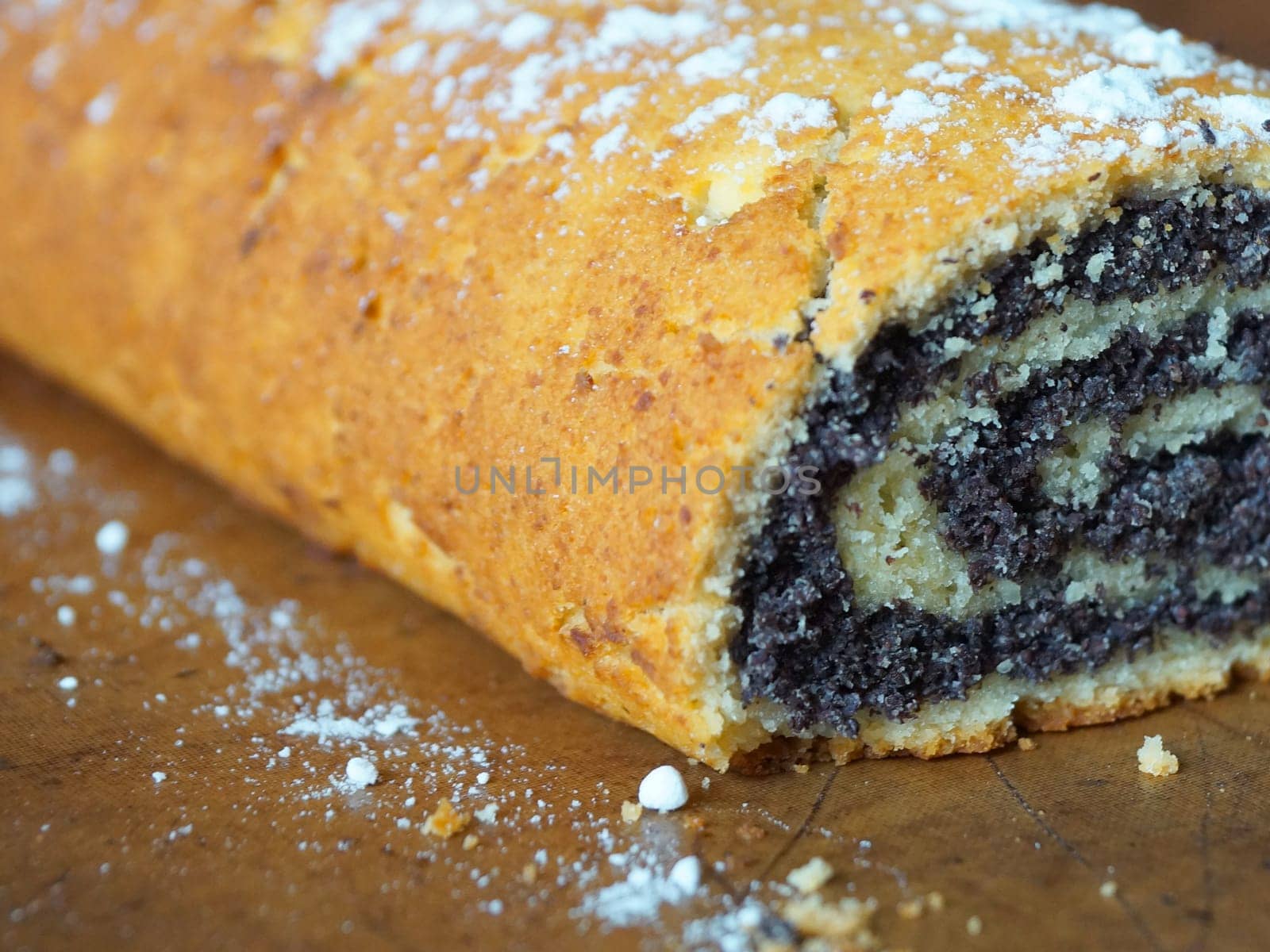 close-up of poppy seed roll sprinkled with powdered sugar by Annado