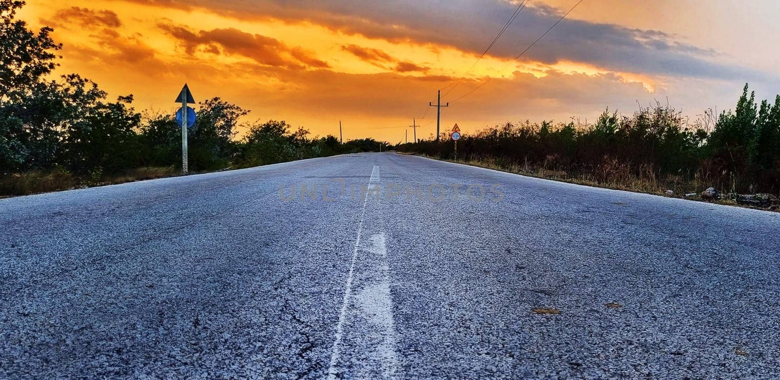 Concept shot of the road in the rural village. Dramatic sunset