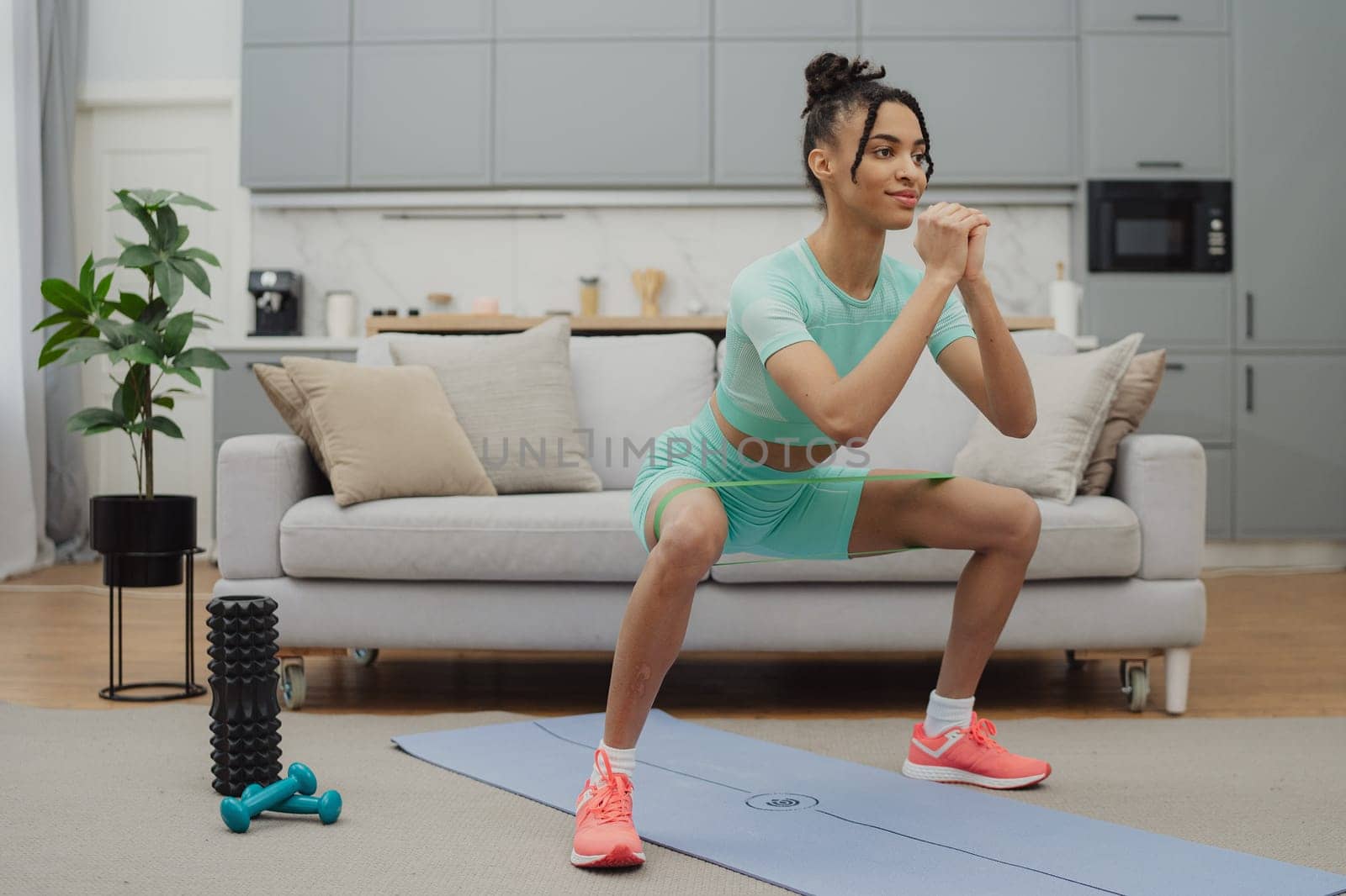 Training to become the best. Beautiful young woman in sports clothing exercising at home.