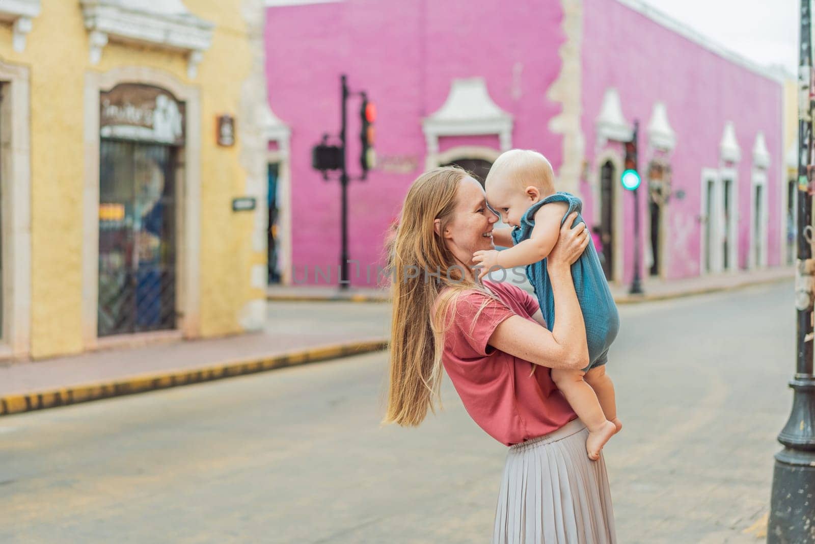 Mother and baby son tourists explore the vibrant streets of Valladolid, Mexico, immersing herself in the rich culture and colorful architecture of this charming colonial town.